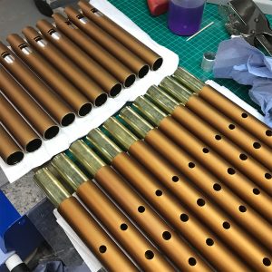 10 Bronze MK Pro Low D Whistles on workbench in workshop